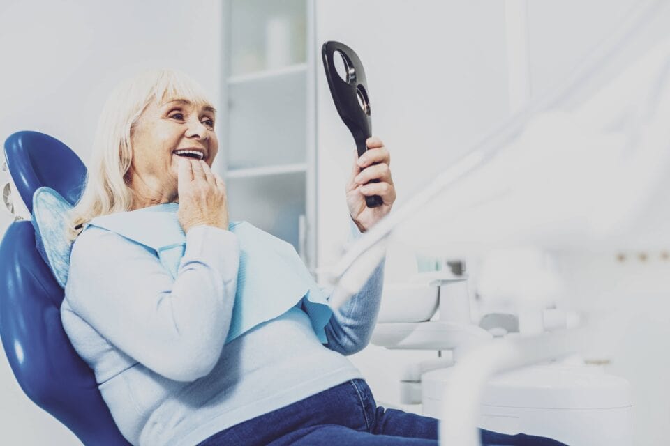 Cheerful mature woman sitting in dentist cabinet